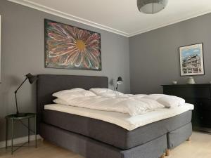 1 cama en un dormitorio con una pintura en la pared en ApartmentInCopenhagen Apartment 1423, en Copenhague