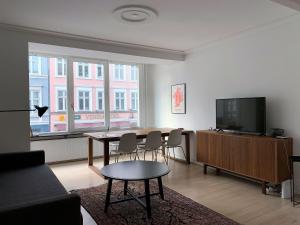 een woonkamer met een tafel en een flatscreen-tv bij ApartmentInCopenhagen Apartment 1423 in Kopenhagen