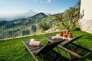 a table and chairs with a view of a mountain at Taormina Rooms Panoramic Apartments in Taormina