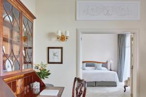 a bedroom with a bed and a table with a chair at Reid's Palace, A Belmond Hotel, Madeira in Funchal