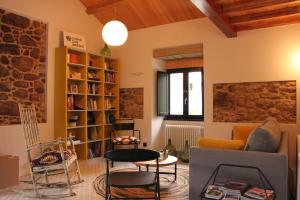 a living room with chairs and a table and a book shelf at Lugar das Marías in Jove