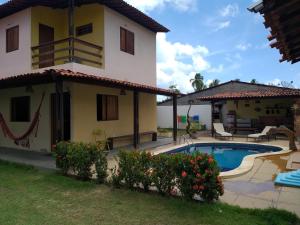 a villa with a swimming pool and a house at Chalé dos Milagres 01 in São Miguel dos Milagres