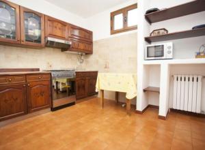 a kitchen with wooden cabinets and a table in it at Sole&Luna in San Teodoro
