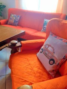 an orange couch with a pillow with a car on it at Nonna Sicilia B&B in Capri Leone
