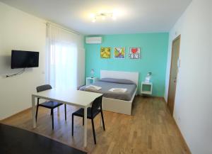アンドリアにあるMozÁrt Bed & Breakfast - Affittacamereのベッドルーム1室(ベッド1台、テーブル、椅子付)