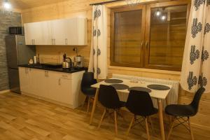 a kitchen with a table and chairs in a kitchen at Domki pod Skocznią in Zakopane