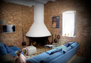 Una sala de estar con un sofá azul y una pared de piedra. en Partida de la Mar, en Almácera