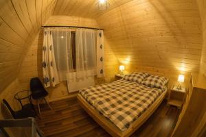 een slaapkamer met een bed in een houten hut bij Domki pod Skocznią in Zakopane