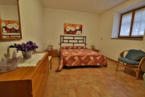 um quarto com uma cama, uma mesa e uma cadeira em Villa Orizzonte em Castelnuovo Berardenga