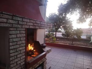 a brick fireplace with a fire in it at Dva lava in Podaca