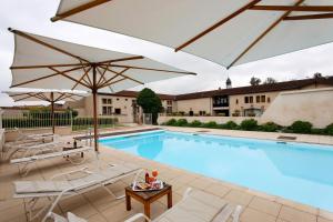 a swimming pool with two umbrellas and chairs and a table at Château d'Adomenil in Rehainviller
