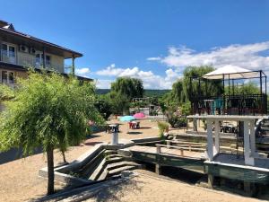 a park with benches and tables and umbrellas at Hanul Popasul Pescarilor in Ostrovu Corbului