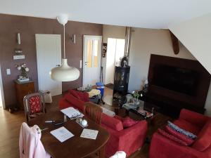 a living room with a table and red chairs at Ferienwohnung Fargau in Schlesen