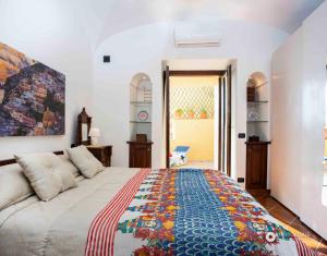 a bedroom with a bed with a colorful blanket on it at Estate4home - Namily house in Positano