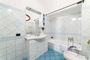 a bathroom with a sink and a tub and a toilet at Estate4home - Namily house in Positano