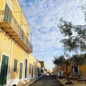 an empty street in a town with yellow buildings at Casa Calanave 2 in Ventotene