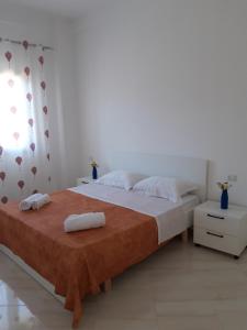 a bedroom with a large bed with two towels on it at Villa Fredi in Orikum