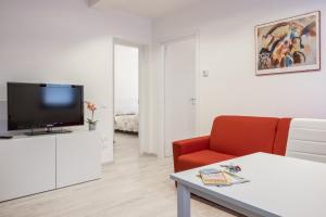 un soggiorno con TV e sedia rossa di Ca' D'oro Apartment - Wi-Fi a Venezia