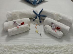 three rolled up towels with a clock on a bed at Residenza Solferino in Corniglia +116 photos