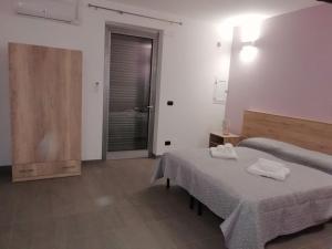 een slaapkamer met 2 bedden en een deur naar een badkamer bij B&B Italia in Carmiano