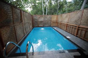 an outdoor swimming pool with a wooden fence at GoGo Land Resort & Adventurous Sports in Pūvār