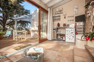 eine Küche mit einer Terrasse mit einem Tisch und einem Kühlschrank in der Unterkunft Mimma del Mar in Santa Teresa Gallura
