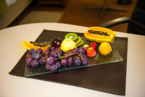 a plate with fruits and vegetables on a table at Slaviero Hotel Porto Alegre Moinhos in Porto Alegre