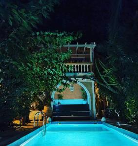 a swimming pool at night with a staircase above it at Danae Villa in Fira