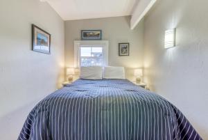 een slaapkamer met een bed met blauwe en witte strepen bij Allegra's Cottage in Eureka