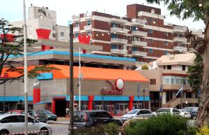 Una calle de la ciudad con coches aparcados delante de un edificio. en EDIFICIO CABO FRIO. I, en Pinamar
