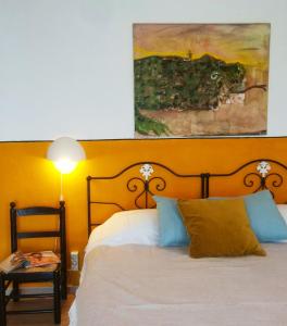 een slaapkamer met een bed en een schilderij aan de muur bij Verdemar in Cercal