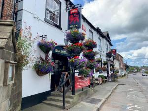 un bâtiment avec des pots de fleurs sur son côté dans l'établissement Red Lion Coaching Inn, à Ellesmere