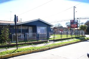 un edificio azul con una valla delante en HOSTAL COLLAO, en Concepción