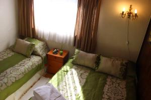 uma sala de estar com duas camas e uma janela em HOSTAL COLLAO em Concepción