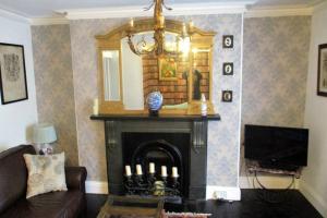 - un salon avec une cheminée et un miroir dans l'établissement COOKS CABIN, à Plymouth