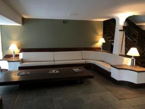 a living room with a couch and a coffee table at Hotel Guarujá Inn Tropical in Guarujá