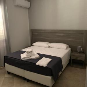 a bedroom with a bed with two towels on it at Stanza vacanza lo stadio in Sibari +11 photos