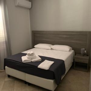 um quarto com uma cama com duas toalhas em Stanza vacanza lo stadio em Sibari