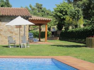 a swimming pool with an umbrella and chairs and a table and an umbrella at CASA LA GRANJA in Olvan