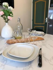un piatto bianco su un tavolo con bicchieri da vino di Les Palmiers de Gruissan, T2, Vue Port ! a Gruissan