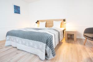 Billum比卢姆库洛酒店的卧室里有一张床，床上铺着蓝白相间的毯子