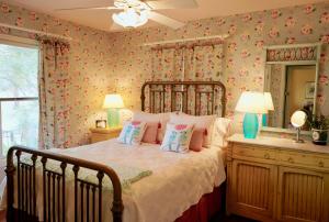 a bedroom with a large bed with floral wallpaper at Onion Creek Cottage in Austin
