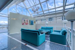 a waiting room with blue chairs and a table at Melbu Hotell in Melbu