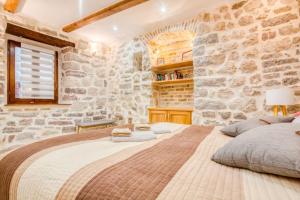 Un dormitorio con una cama grande en una pared de piedra. en Kotor Bagus - Cozy Boutique Old Town Studio with Seaview Terrace, en Kotor 17 fotos más