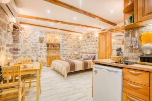 a kitchen and a bedroom with a bed in a room at Kotor Bagus - Cozy Boutique Old Town Studio with Seaview Terrace in Kotor