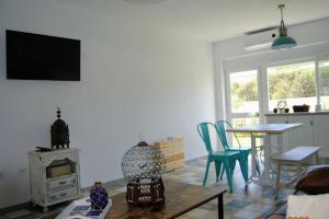 ein Wohnzimmer mit Tisch und Stühlen und einem Fernseher in der Unterkunft Arabias Loft Caños de Meca in Los Caños de Meca