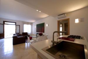 a kitchen and living room with a couch and a sink at VILLA DELFINI 2-12 Pax in San Vito lo Capo