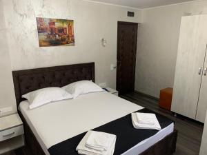 1 dormitorio con 1 cama con 2 toallas en Pensiunea Adriano, en Brăila