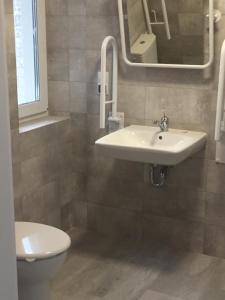 ein Badezimmer mit Waschbecken, Toilette und Spiegel in der Unterkunft Armona in Ustka