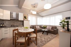 eine Küche und ein Wohnzimmer mit einem Tisch und einem Sofa in der Unterkunft Apartman Slavica in Rijeka